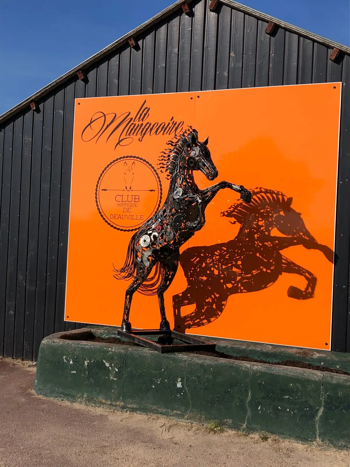 L’enseigne orange de La Mangeoire sur le bâtiment du club