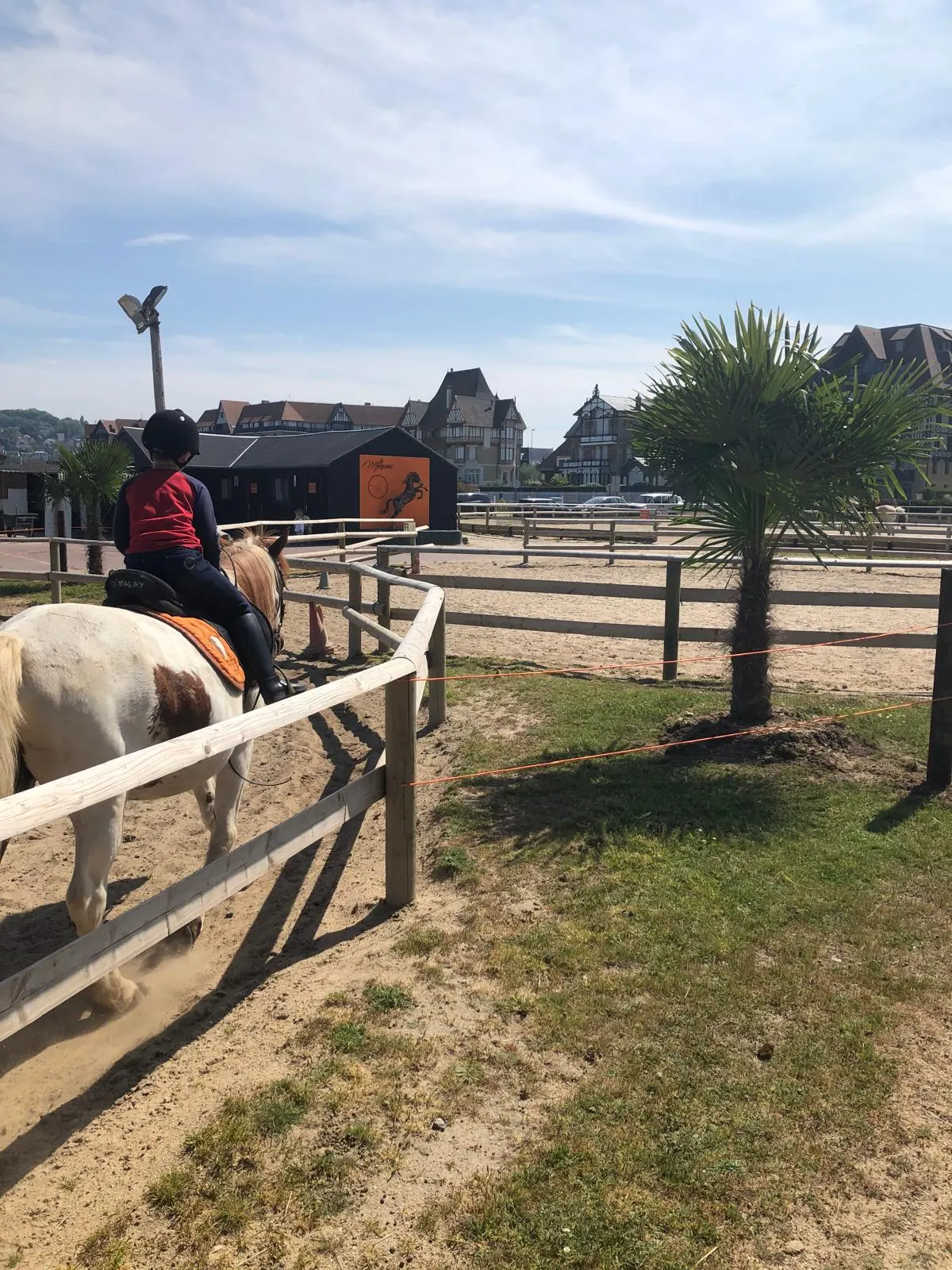 Un bambino su un pony vicino alle scuderie